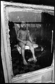 Krem, après avoir couru nu dans tout l'appartement par jeu, se repose sur une chaise dans la cuisine.